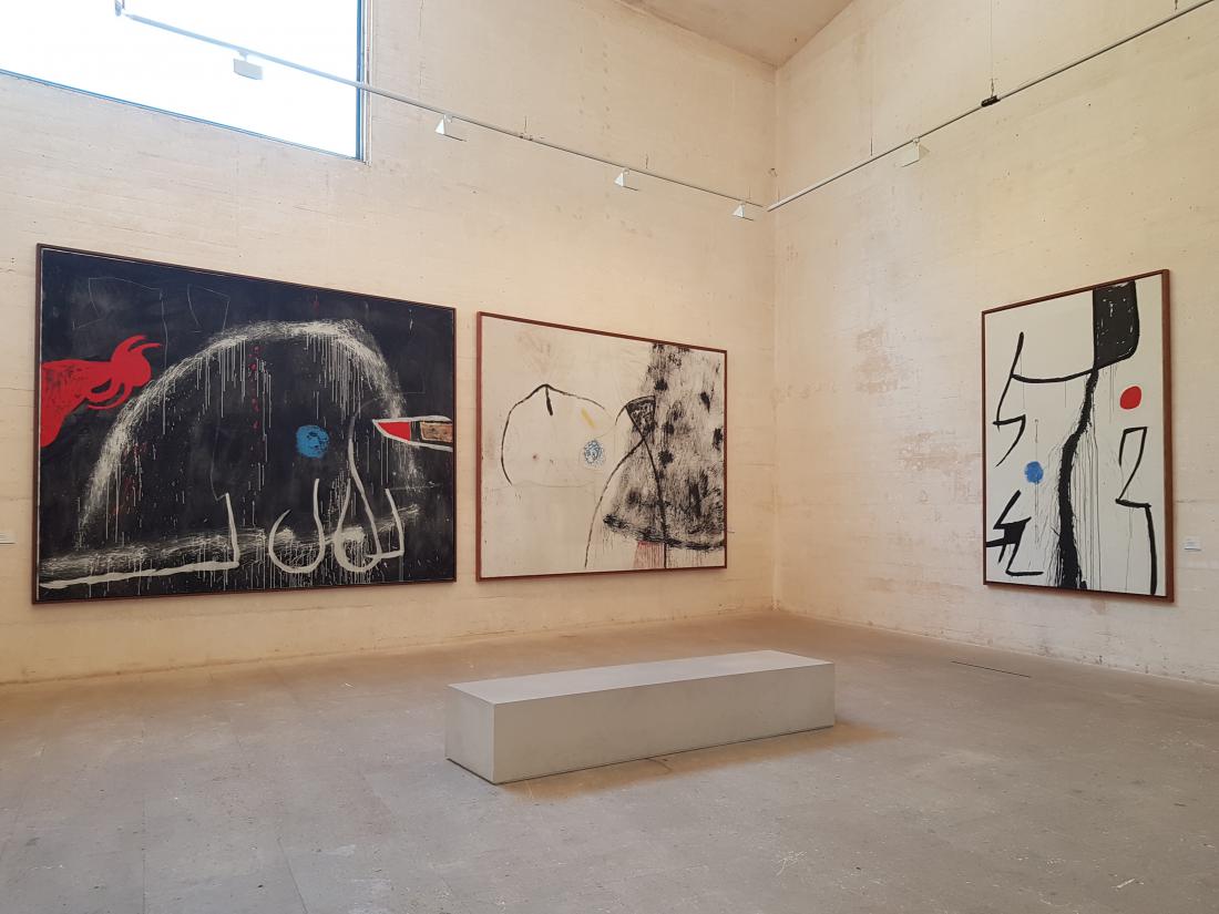 Izčiščene betonske stene v notranjosti ponujajo minimalistično ozadje za Mirójeva platna.